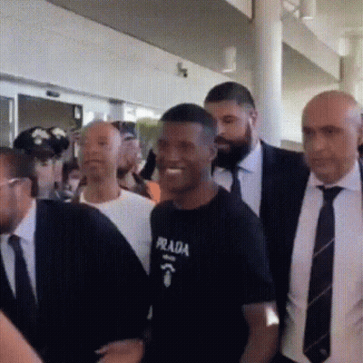 Man In Prada Shirt Surrounded By Suits And Ties GIF