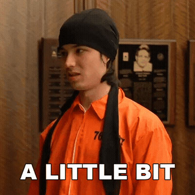 Man In Prison Uniform Says A Little Bit Wearing Black Hat GIF