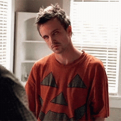 Man In Pumpkin Shirt Looks At Another Man GIF