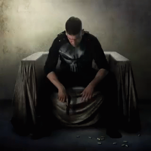 Man In Punisher Costume Sitting GIF