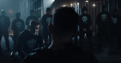 Man In Punisher Sweatshirt In Front Of Clowns GIF
