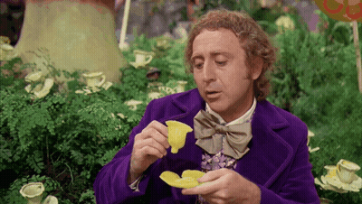 Man in Purple Coat and Bow Tie Holding Yellow Flower