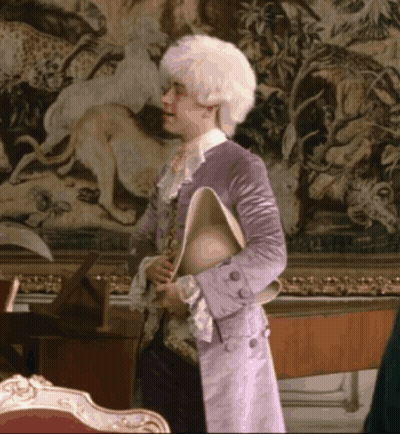 Man In Purple Coat Holding Hat GIF