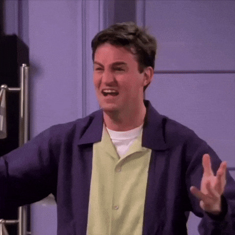 Man In Purple Jacket And Green Shirt Making Funny Face At Door GIF