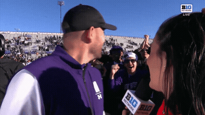 Man In Purple Jacket Interviewed By Woman With Microphone GIF