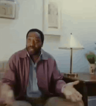 Man In Purple Jacket Sitting On Couch GIF