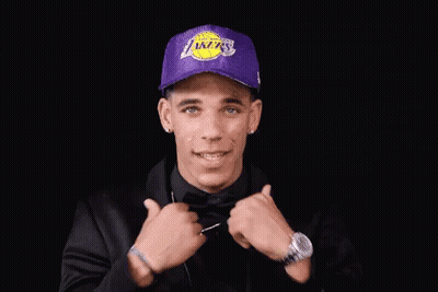 Man In Purple Lakers Hat And Black Jacket Adjusting Tie GIF