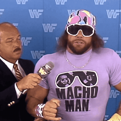Man In Purple Macho Shirt Being Interviewed GIF
