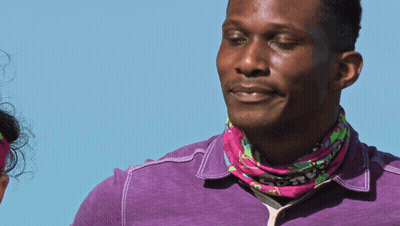Man In Purple Shirt And Pink Bandana Looking To Side GIF