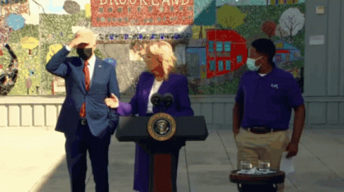 Man In Purple Shirt And Woman Behind Podium GIF