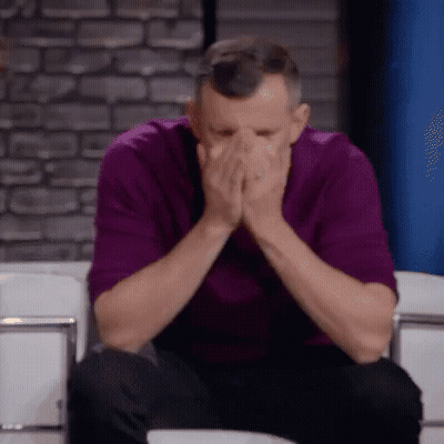 Man in Purple Shirt Covering Face