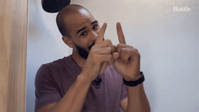 Man In Purple Shirt Gesturing Says Bustle GIF