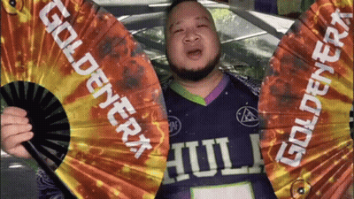 Man In Purple Shirt Holding Goldenera Fan GIF