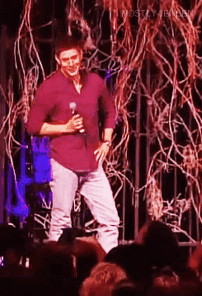 Man In Purple Shirt Holding Microphone On Stage GIF
