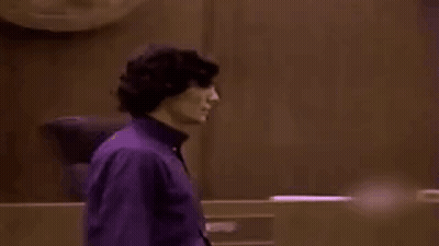 Man In Purple Shirt In Dark Room GIF