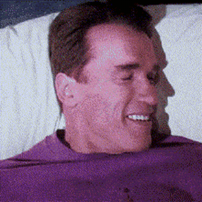 Man In Purple Shirt Laying On Bed Smiling GIF