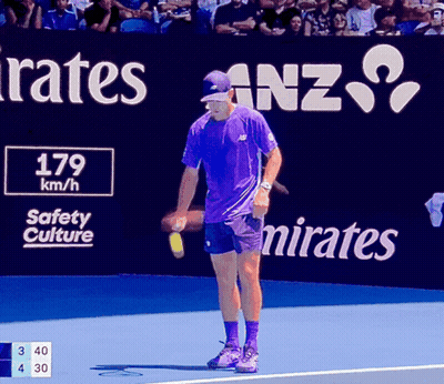 Man In Purple Shirt On Tennis Court In Front Of Emirates Sign GIF