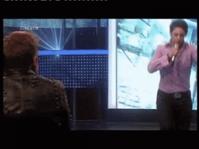 Man In Purple Shirt Singing Into Microphone GIF