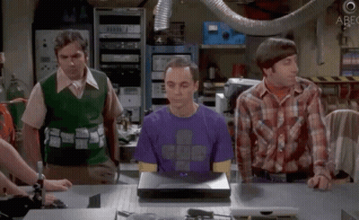 Man In Purple Shirt Sitting At Laptop With Two Men Looking On GIF