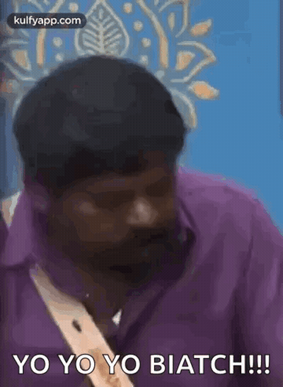 Man In Purple Shirt Talking In Front Of Blue Wall GIF