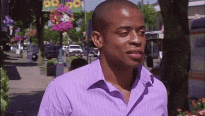 Man In Purple Shirt Walking Down Street GIF