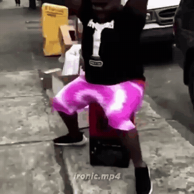 Man In Purple Shorts Standing On Sidewalk GIF
