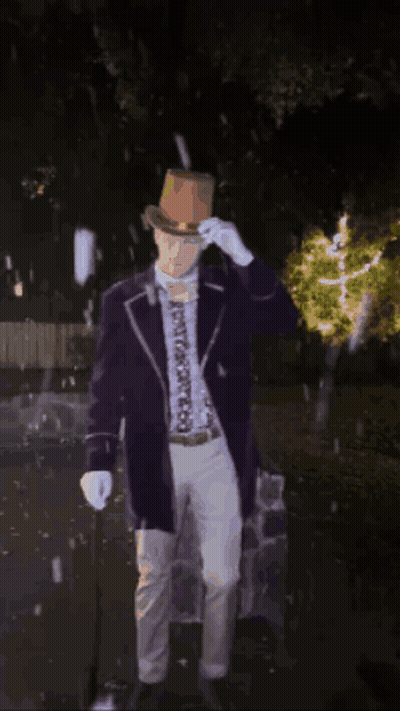 Man In Purple Suit And Brown Hat Standing In Dark GIF