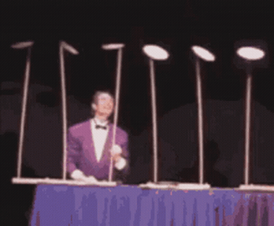 Man In Purple Suit Beside Metal Poles With Plates GIF