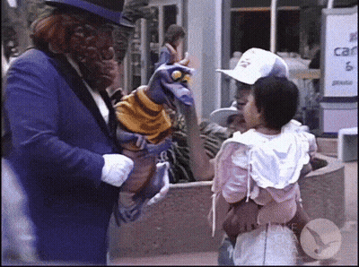 Man In Purple Suit Holding Puppet Talking To Little Girl GIF