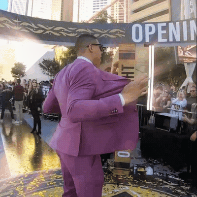 Man In Purple Suit In Front Of Open Sign GIF