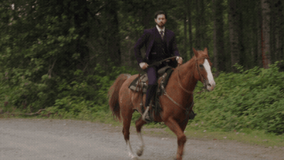 Man In Purple Suit Riding Brown Horse GIF