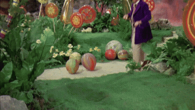 Man in Purple Suit Standing in Garden With Lollipops