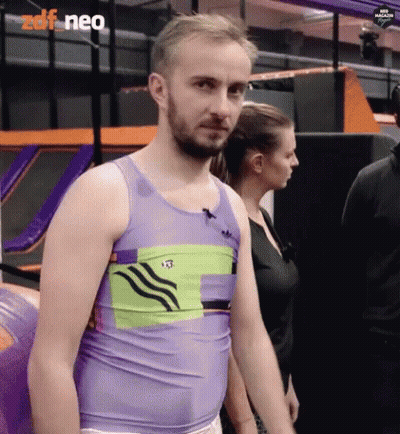 Man In Purple Tank Top Standing In Front Of Woman In Black Shirt GIF