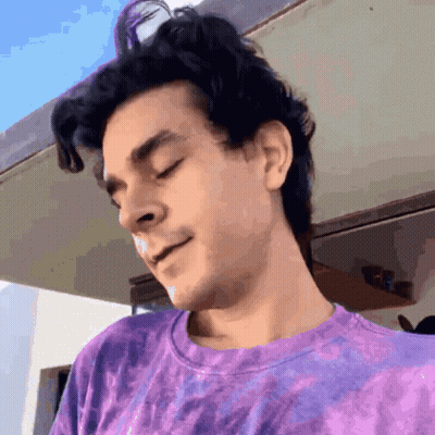 Man In Purple Tie-Dye T-Shirt With Eyes Closed Looking Down GIF