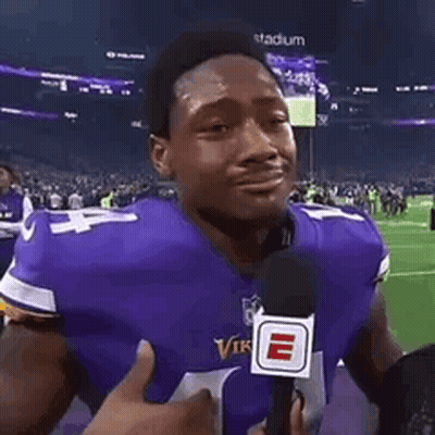 Man In Purple Vikings Jersey Holding Microphone Crying On Football Field GIF