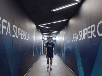Man In Qatar Shirt Walking Through Hallway GIF