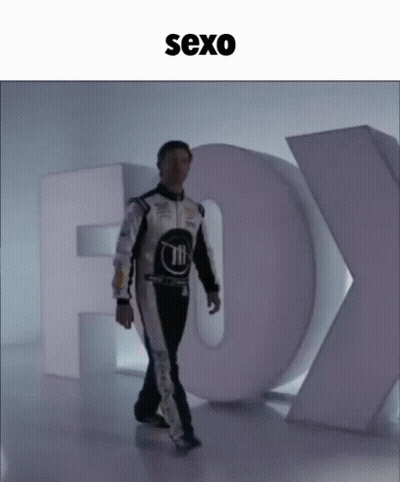 Man In Race Suit Walking Past Fox Sign GIF