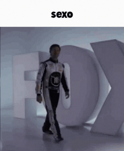 Man In Race Suit Walking Past Fox Sign GIF