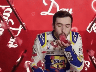 Man In Racing Suit Blowing Kiss GIF
