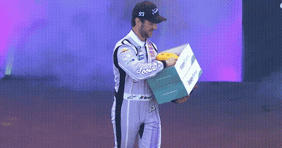 Man In Racing Suit Holding Foodie Box GIF