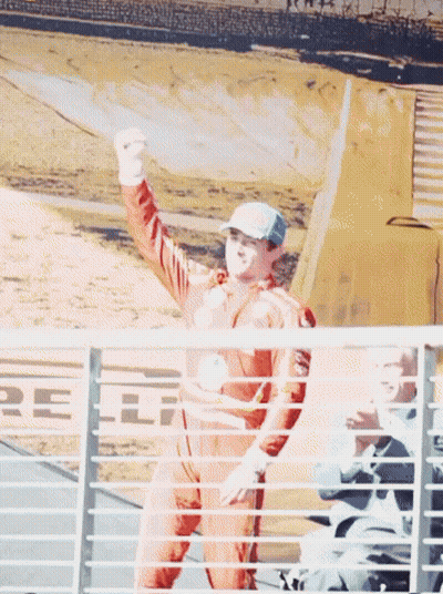 Man In Racing Suit Raising Fist GIF