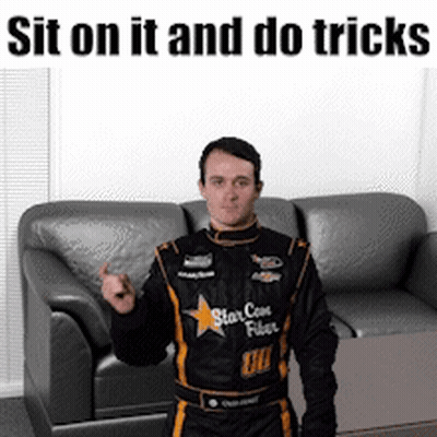 Man In Racing Suit Saying Sit And Do Tricks GIF