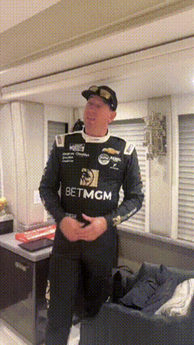 Man In Racing Uniform In Living Room GIF