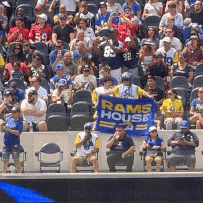 Man In Rams House Shirt Holding Banner GIF