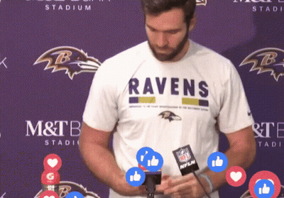 Man In Ravens Shirt In Front Of Purple Wall GIF