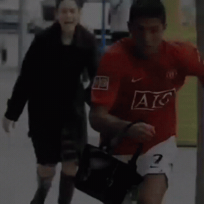 Man In Red AC Jersey Running With Woman GIF