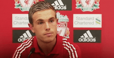 Man In Red Adidas Shirt Sitting In Front Of Red Wall GIF