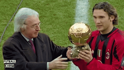 Man In Red And Black Shirt Holding Futbol Karim Trophy GIF