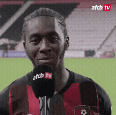Man In Red And Black Shirt Talking Into Microphone GIF
