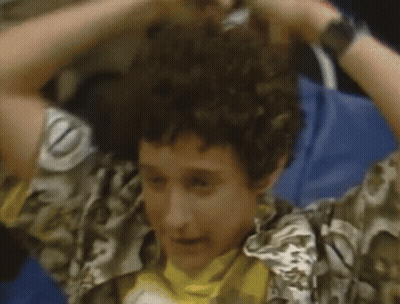 Man In Red And Black Striped Shirt In Front Of NBC Sign Saying Saved By The Bell GIF
